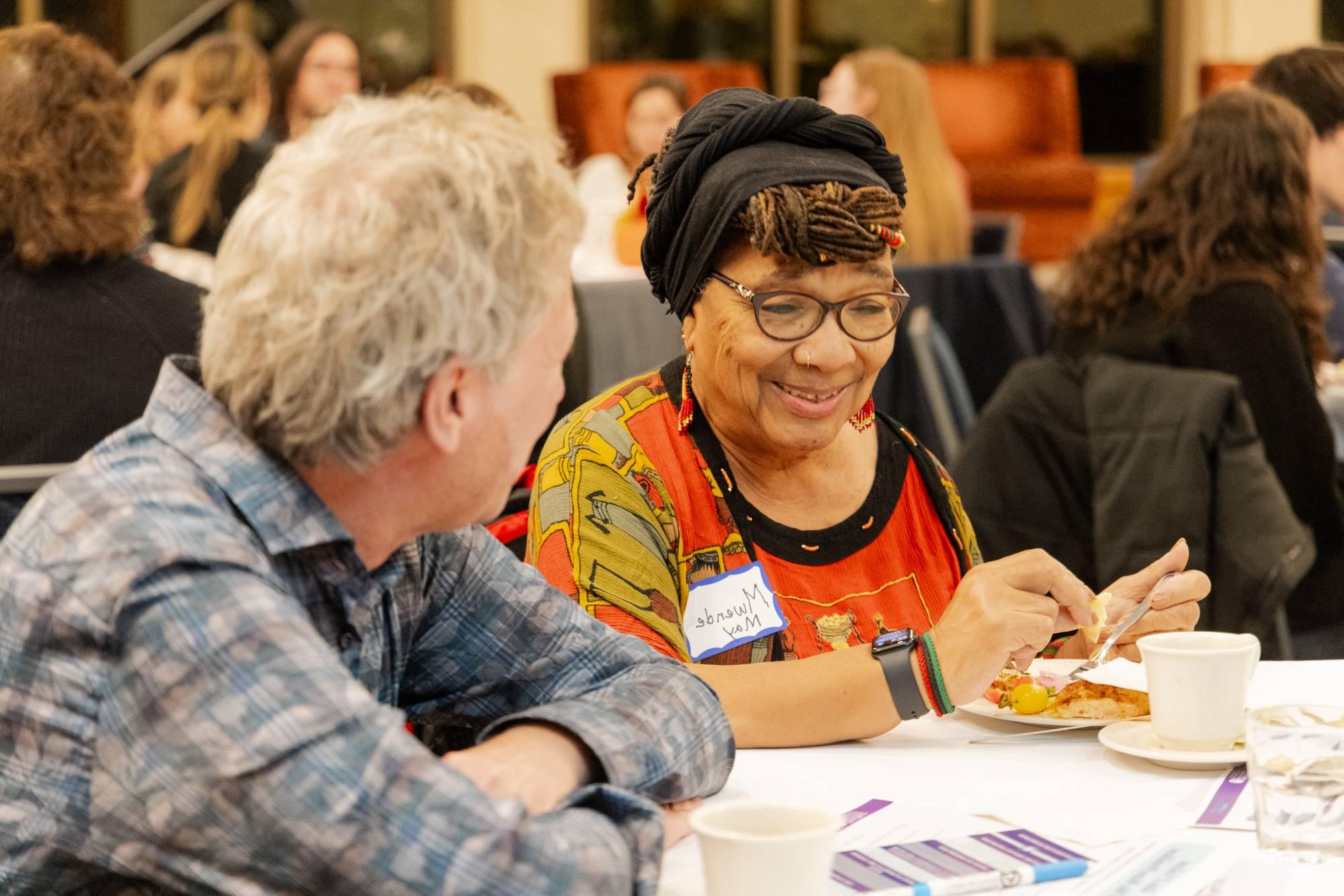 two older attendees smiling at one another